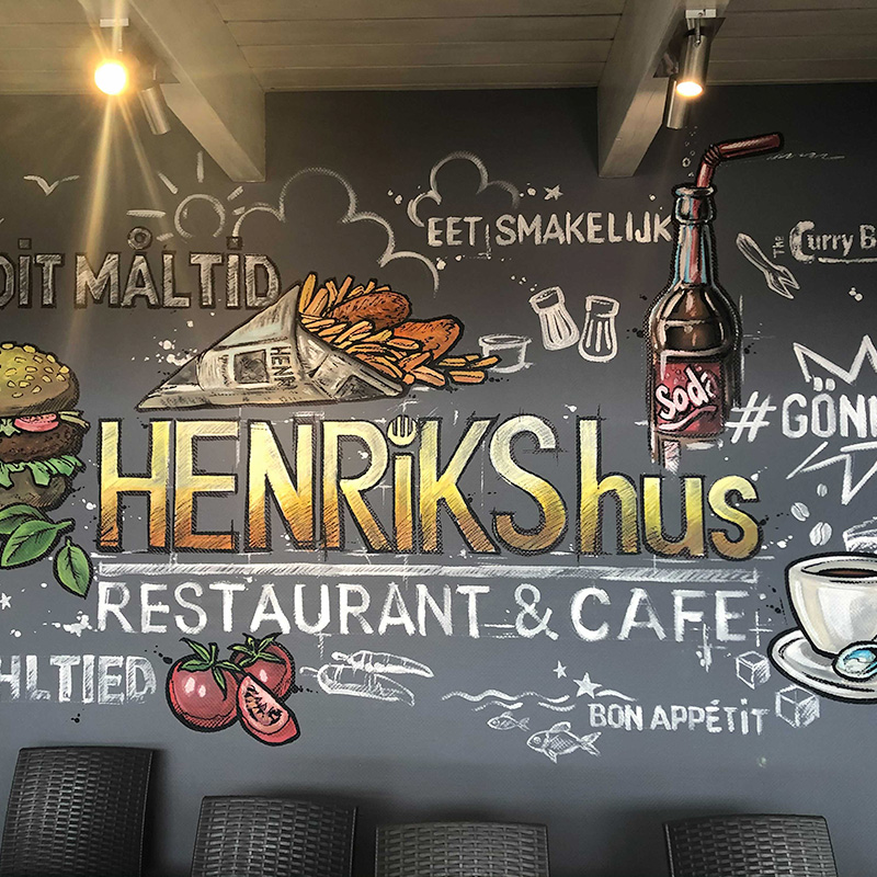 Tafelwand mit Henrik's-Hus-Schriftzug im Restaurant